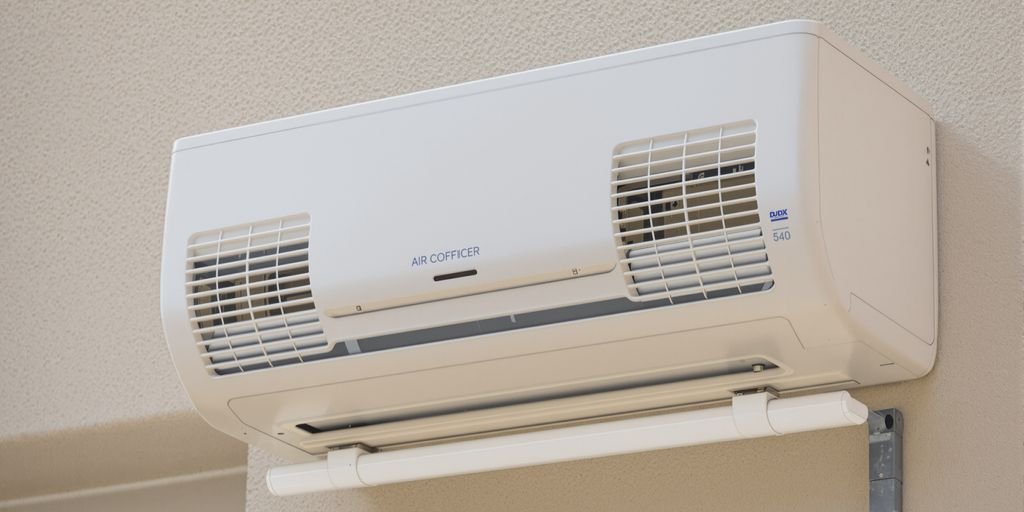 Un climatiseur réversible installé sur un mur extérieur.